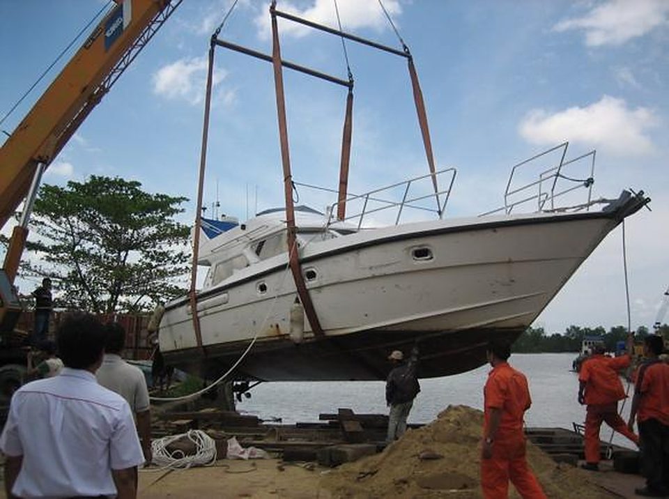 Motor yacht lifted by crane onto trailer